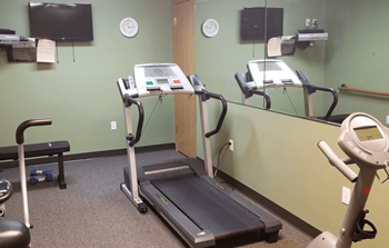 A gym room with a treadmill and exercise bike.